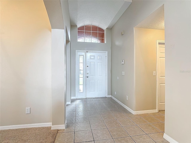 132 Cordova Ave, Davenport, FL 33897 - entryway with light tile patterned flooring, a textured ceiling, and lofted ceiling