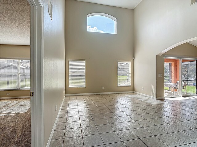 132 Cordova Ave, Davenport, FL 33897 - spare room with arched walkways, a towering ceiling, and tile patterned flooring