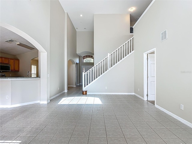 132 Cordova Ave, Davenport, FL 33897 - entryway featuring a towering ceiling, light tile patterned floors, arched walkways, and stairway
