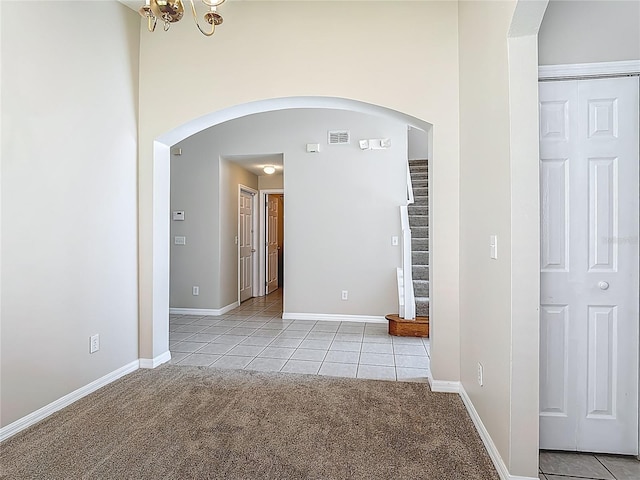 132 Cordova Ave, Davenport, FL 33897 - empty room with light carpet, arched walkways, and light tile patterned floors