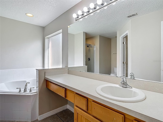 132 Cordova Ave, Davenport, FL 33897 - bathroom featuring a textured ceiling, a garden tub, vanity, tile patterned flooring, and an enclosed shower