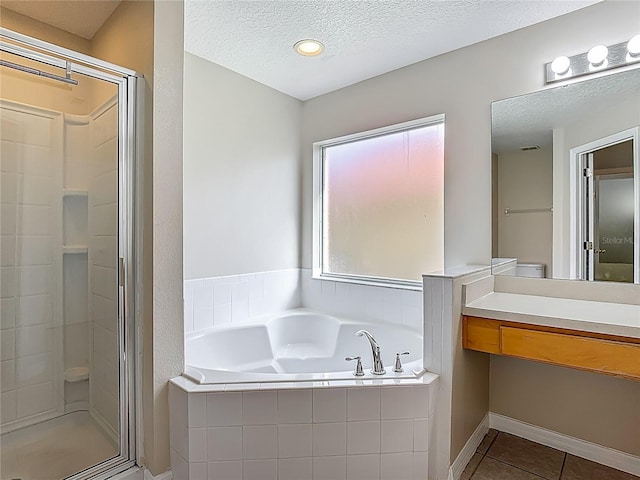 132 Cordova Ave, Davenport, FL 33897 - full bathroom featuring a garden tub, a shower stall, vanity, a textured ceiling, and tile patterned flooring