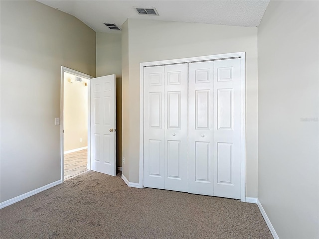 132 Cordova Ave, Davenport, FL 33897 - unfurnished bedroom with lofted ceiling, carpet floors, and a closet