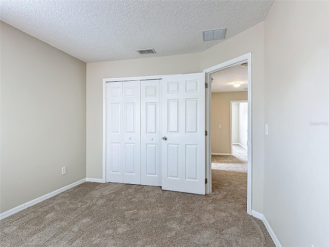 132 Cordova Ave, Davenport, FL 33897 - unfurnished bedroom featuring carpet floors, a textured ceiling, and a closet