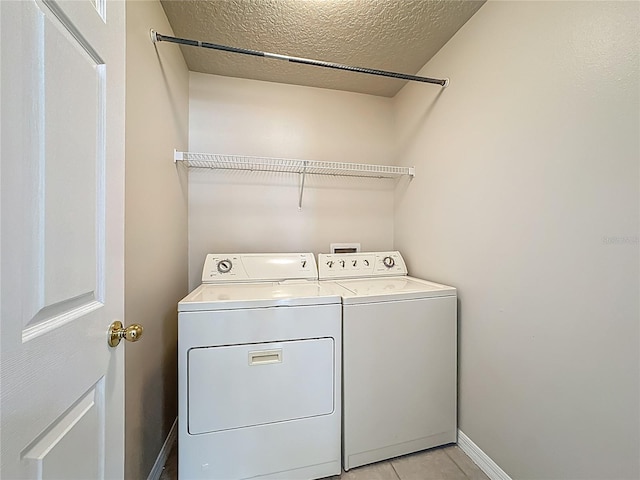132 Cordova Ave, Davenport, FL 33897 - washroom with washer and dryer, a textured ceiling, and light tile patterned flooring