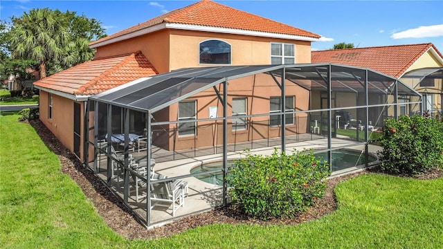 132 Cordova Ave, Davenport, FL 33897 - rear view of house with a tiled roof, a patio area, stucco siding, and a lawn