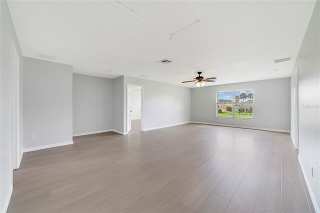 2298 The Oaks Blvd, Kissimmee, FL 34746 - unfurnished room featuring wood finished floors, a ceiling fan, and attic access