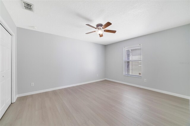 2298 The Oaks Blvd, Kissimmee, FL 34746 - unfurnished bedroom with light wood-type flooring, a closet, ceiling fan, and a textured ceiling