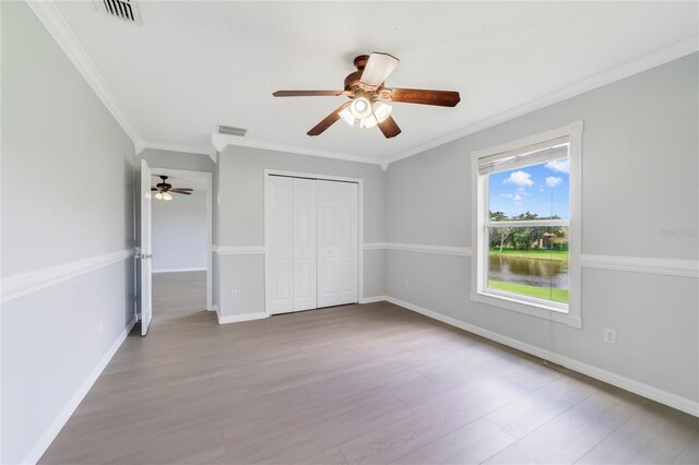 2298 The Oaks Blvd, Kissimmee, FL 34746 - unfurnished bedroom with crown molding, wood finished floors, a closet, and a ceiling fan
