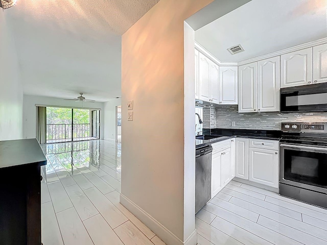 6140 Burnside Cir Unit 204, Orlando, FL 32822 - kitchen with stainless steel appliances, dark countertops, tasteful backsplash, and white cabinets