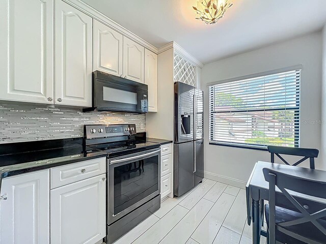 6140 Burnside Cir Unit 204, Orlando, FL 32822 - kitchen featuring appliances with stainless steel finishes, dark countertops, backsplash, and white cabinetry