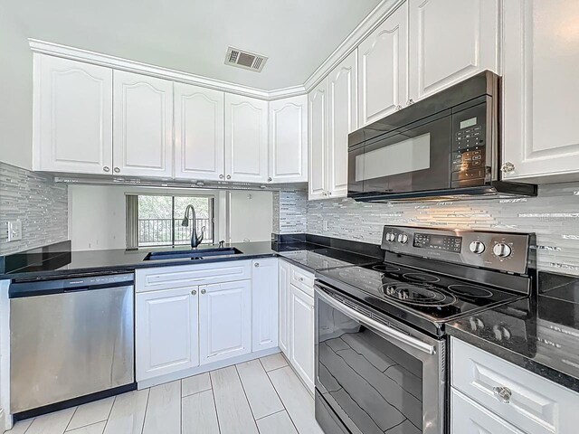 6140 Burnside Cir Unit 204, Orlando, FL 32822 - kitchen with appliances with stainless steel finishes, white cabinets, tasteful backsplash, and dark stone countertops
