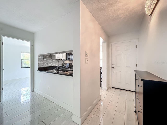 6140 Burnside Cir Unit 204, Orlando, FL 32822 - kitchen with dark countertops, wood finish floors, tasteful backsplash, a textured ceiling, and black microwave