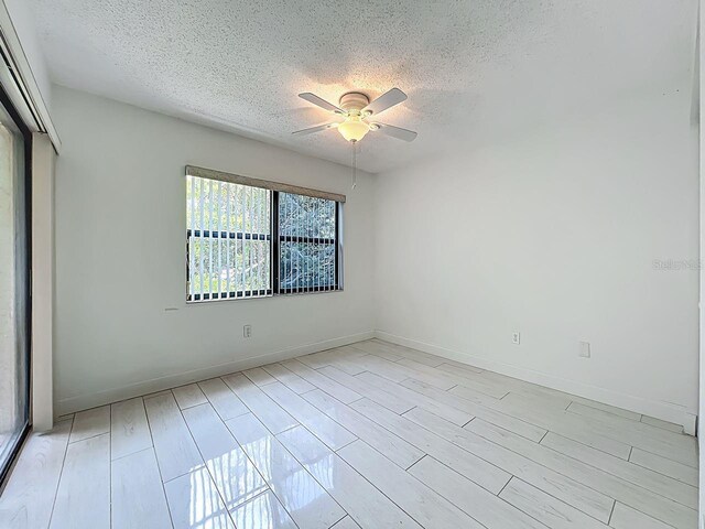 6140 Burnside Cir Unit 204, Orlando, FL 32822 - empty room with a textured ceiling, ceiling fan, and light wood-style flooring