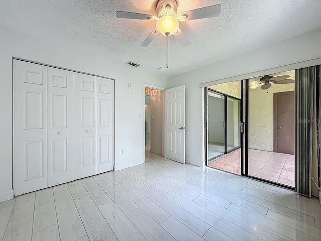 6140 Burnside Cir Unit 204, Orlando, FL 32822 - unfurnished bedroom with a textured ceiling, light wood-style flooring, and ceiling fan