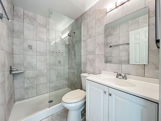6140 Burnside Cir Unit 204, Orlando, FL 32822 - bathroom with tile walls, vanity, a tile shower, tile patterned flooring, and decorative backsplash