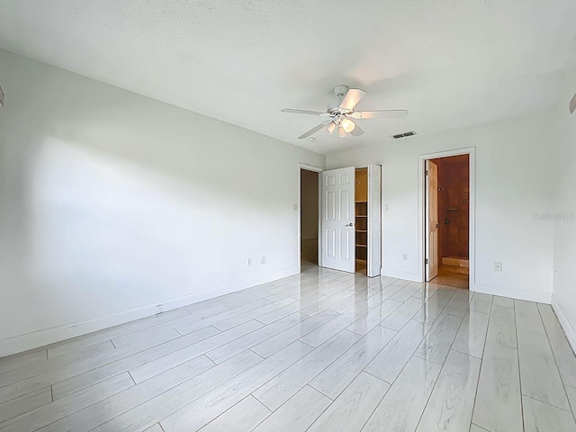 6140 Burnside Cir Unit 204, Orlando, FL 32822 - unfurnished bedroom with a spacious closet, light wood-style floors, a ceiling fan, and ensuite bathroom