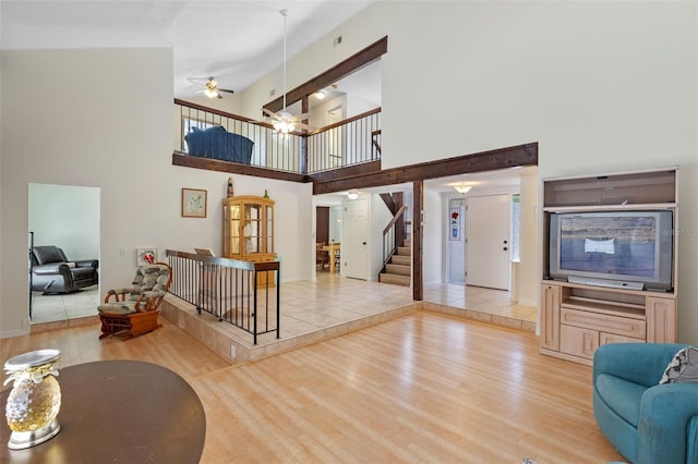 5630 Spring Run Ave, Orlando, FL 32819 - living room with wood finished floors, a towering ceiling, ceiling fan, and stairs