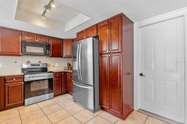 5630 Spring Run Ave, Orlando, FL 32819 - kitchen featuring appliances with stainless steel finishes, light tile patterned flooring, a tray ceiling, rail lighting, and decorative backsplash