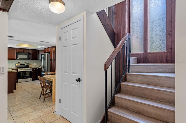 5630 Spring Run Ave, Orlando, FL 32819 - stairway with a textured ceiling and tile patterned flooring