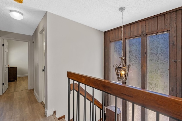 5630 Spring Run Ave, Orlando, FL 32819 - hall featuring an upstairs landing, light wood-style floors, and a textured ceiling