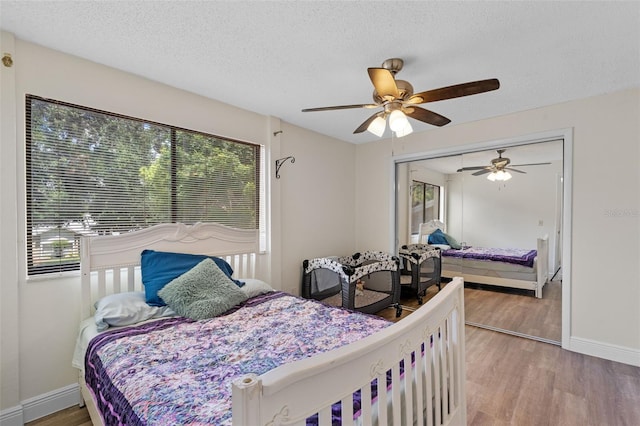 5630 Spring Run Ave, Orlando, FL 32819 - bedroom featuring wood finished floors, a textured ceiling, a closet, and ceiling fan