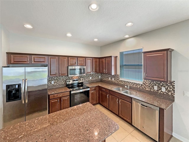 2587 Isabela Ter, Kissimmee, FL 34743 - kitchen featuring appliances with stainless steel finishes, backsplash, dark stone countertops, light tile patterned flooring, and recessed lighting