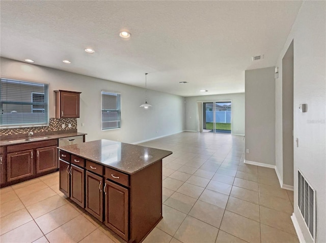2587 Isabela Ter, Kissimmee, FL 34743 - kitchen with decorative backsplash, light tile patterned floors, a center island, decorative light fixtures, and recessed lighting
