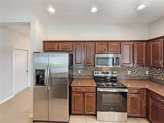2587 Isabela Ter, Kissimmee, FL 34743 - kitchen with stainless steel appliances, backsplash, dark stone counters, light tile patterned flooring, and recessed lighting