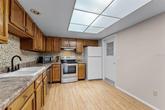 1384 La Paloma Cir, Winter Springs, FL 32708 - kitchen with stainless steel appliances, under cabinet range hood, light wood-style floors, and decorative backsplash