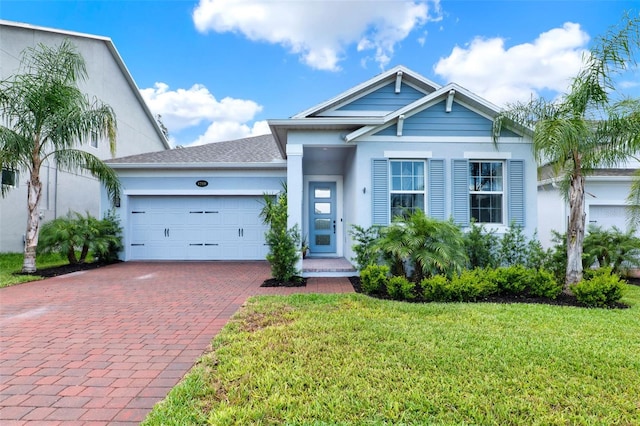 1219 Foltz Loop, Oakland, FL 34787 - view of front of house featuring stucco siding, decorative driveway, a garage, a front lawn, and a shingled roof