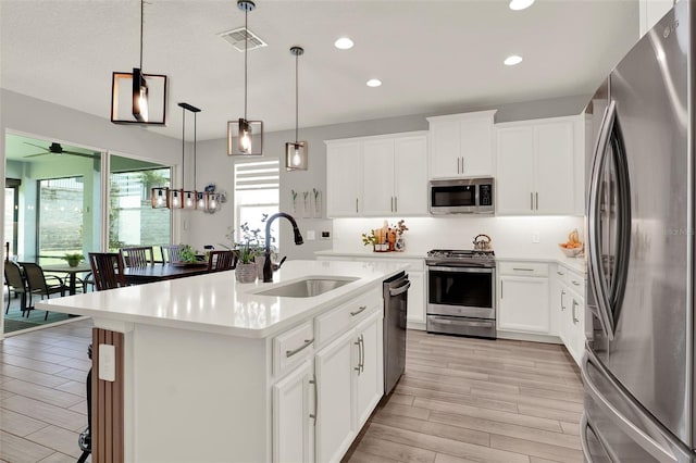 1219 Foltz Loop, Oakland, FL 34787 - kitchen with stainless steel appliances, recessed lighting, light countertops, light wood-type flooring, and hanging light fixtures
