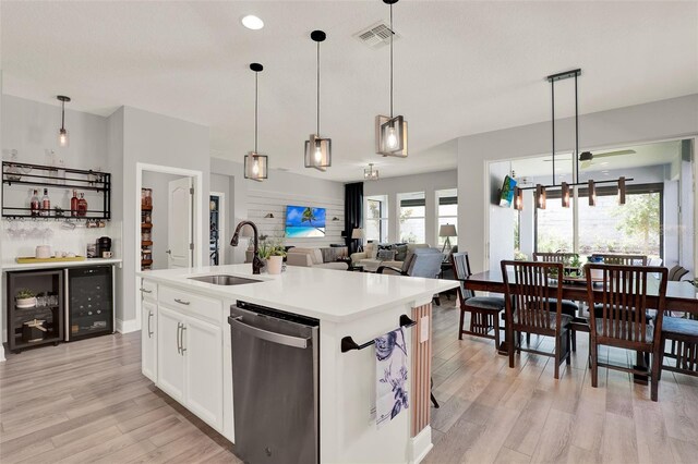 1219 Foltz Loop, Oakland, FL 34787 - kitchen with stainless steel dishwasher, light wood-type flooring, decorative light fixtures, and light countertops