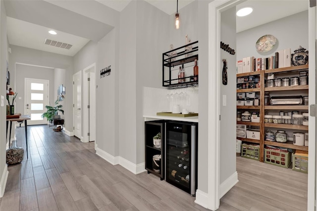 1219 Foltz Loop, Oakland, FL 34787 - hallway with wood finished floors and wine cooler