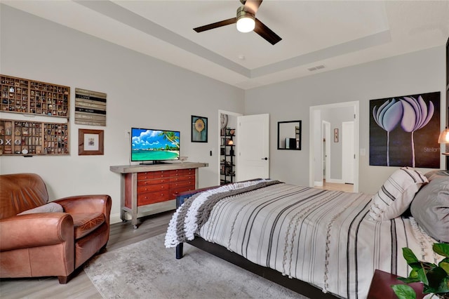 1219 Foltz Loop, Oakland, FL 34787 - bedroom featuring light wood finished floors, a tray ceiling, and a ceiling fan