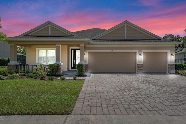 13851 Jomatt Loop, Winter Garden, FL 34787 - view of front of home with stucco siding, decorative driveway, a garage, and covered porch
