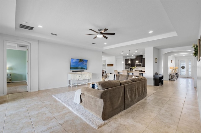 13851 Jomatt Loop, Winter Garden, FL 34787 - living room featuring a raised ceiling, arched walkways, ceiling fan, light tile patterned floors, and recessed lighting