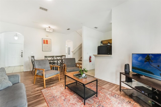 4224 Calabria Ave, Davenport, FL 33897 - living area featuring arched walkways, light wood-style flooring, and stairs