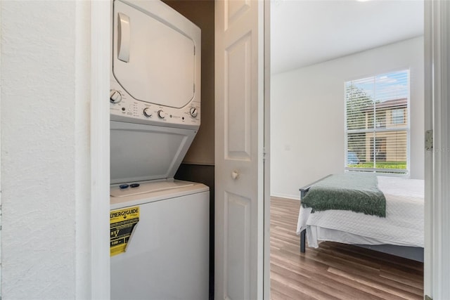 4224 Calabria Ave, Davenport, FL 33897 - laundry area with stacked washing machine and dryer and wood finished floors