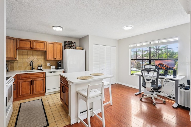 364 Northpointe Ct Unit 208, Altamonte Springs, FL 32701 - kitchen with white appliances, light countertops, brown cabinetry, tasteful backsplash, and a textured ceiling