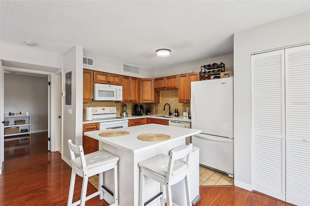 364 Northpointe Ct Unit 208, Altamonte Springs, FL 32701 - kitchen featuring white appliances, light countertops, tasteful backsplash, a breakfast bar area, and light wood finished floors
