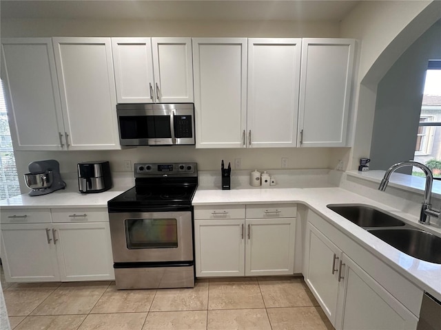10110 SW Chadwick Dr, Port St Lucie, FL 34987 - kitchen featuring stainless steel appliances, light countertops, white cabinetry, and light tile patterned flooring