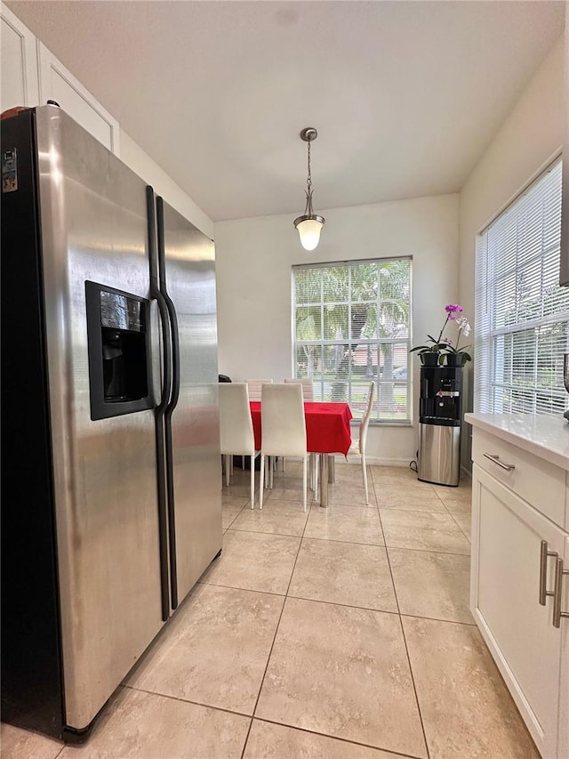 10110 SW Chadwick Dr, Port St Lucie, FL 34987 - kitchen featuring stainless steel fridge, water heater, white cabinets, light countertops, and light tile patterned floors