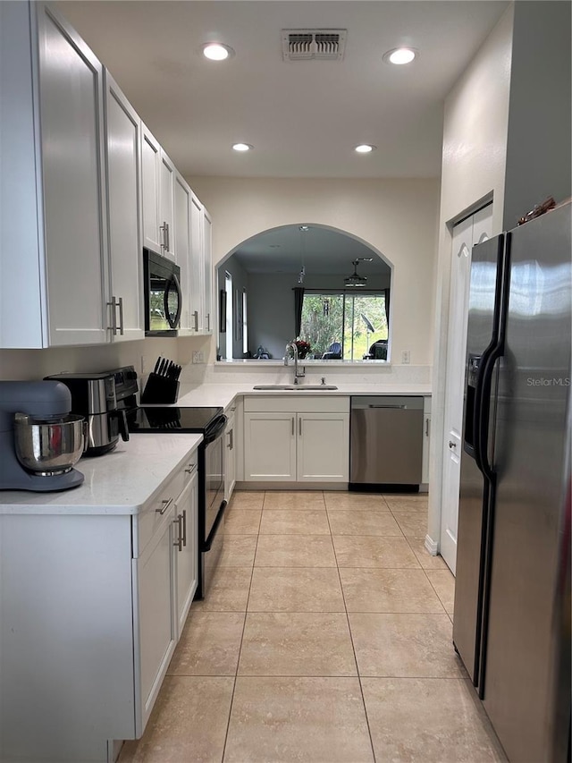 10110 SW Chadwick Dr, Port St Lucie, FL 34987 - kitchen with black appliances, arched walkways, recessed lighting, light countertops, and light tile patterned floors
