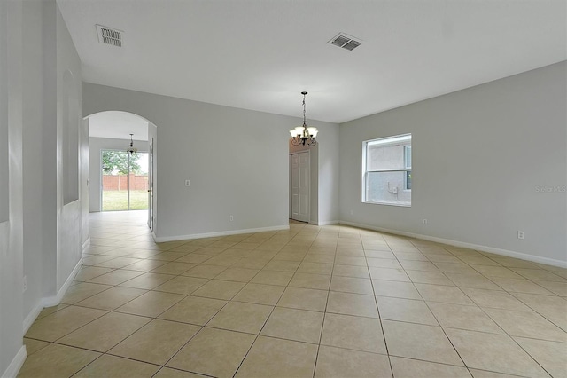 9049 Edenshire Cir, Orlando, FL 32836 - spare room featuring a chandelier, light tile patterned floors, and arched walkways