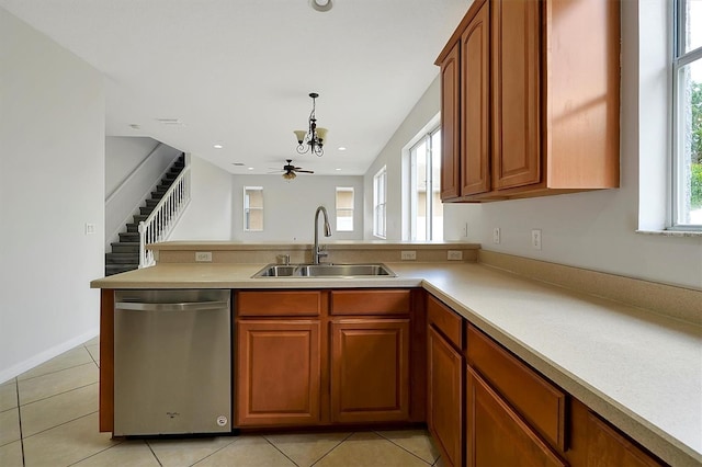9049 Edenshire Cir, Orlando, FL 32836 - kitchen with stainless steel dishwasher, a peninsula, light countertops, a chandelier, and brown cabinets