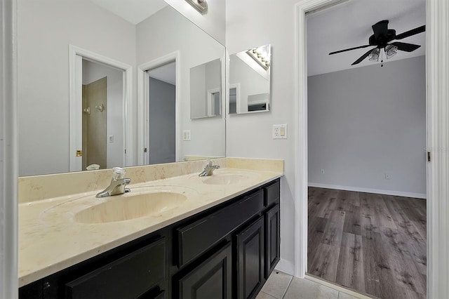 9049 Edenshire Cir, Orlando, FL 32836 - bathroom with double vanity, a ceiling fan, and wood finished floors
