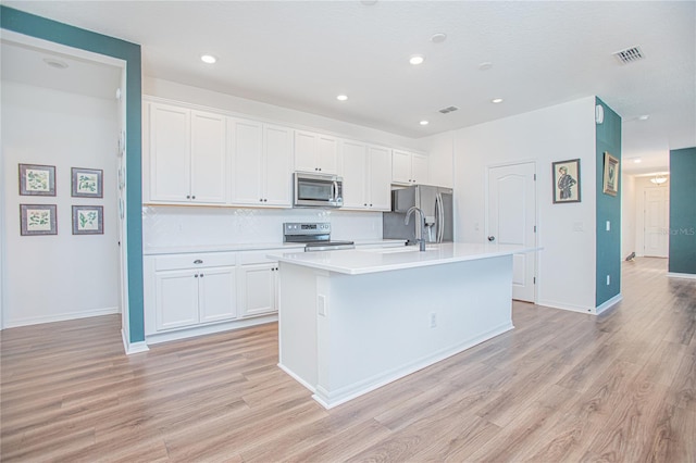 786 Steerview St, Saint Cloud, FL 34771 - kitchen featuring stainless steel appliances, an island with sink, light wood-style flooring, white cabinets, and recessed lighting