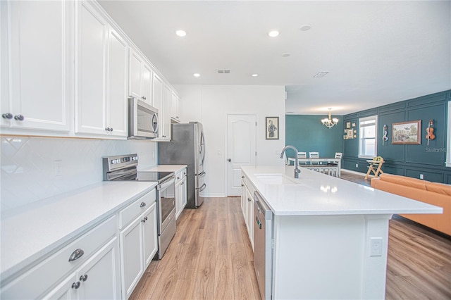 786 Steerview St, Saint Cloud, FL 34771 - kitchen featuring stainless steel appliances, light wood-type flooring, an island with sink, white cabinetry, and light countertops
