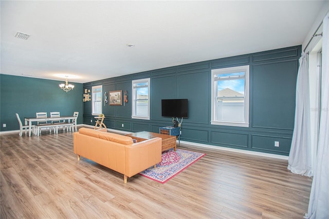 786 Steerview St, Saint Cloud, FL 34771 - living area featuring a decorative wall, a chandelier, wood finished floors, and plenty of natural light